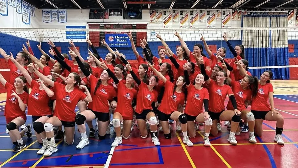 Équipe féminine en maillots rouges réunie dans un gymnase